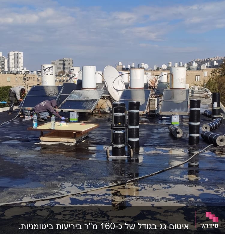 עובדים על גג עם יריעות איטום וכלי עבודה
